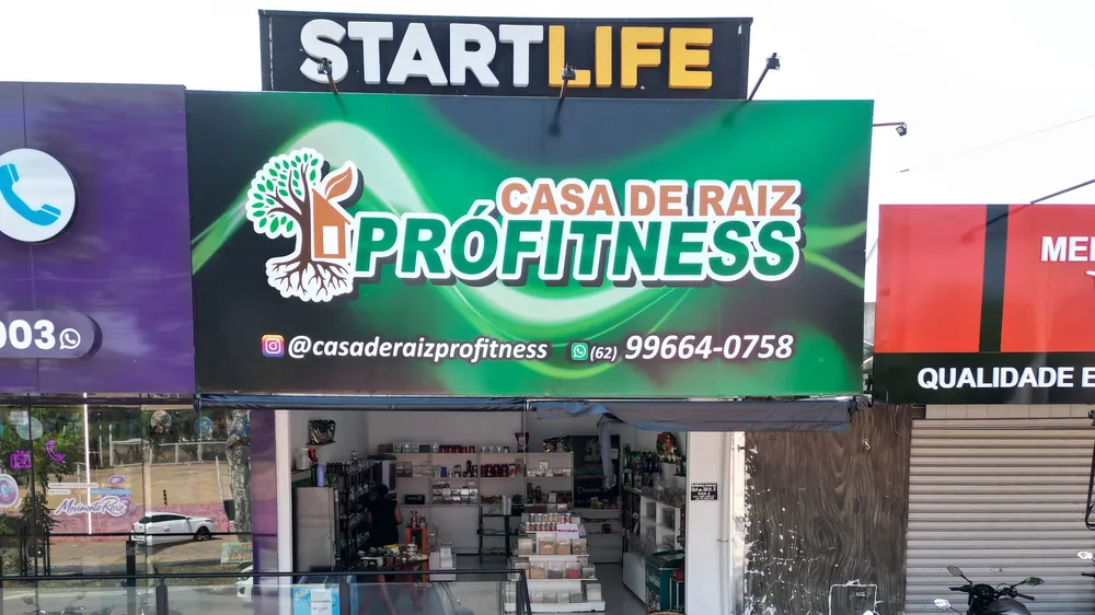 Fachada da Casa de Raiz Prófitness com o letreiro verde, o Instagram e o WhatsApp da loja